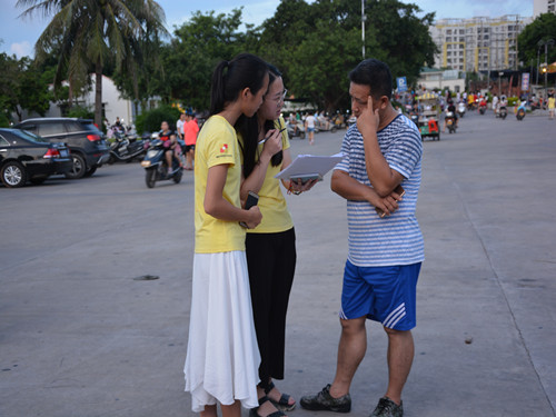 “筑梦川行”队员正向市民介绍国家助学贷款政策